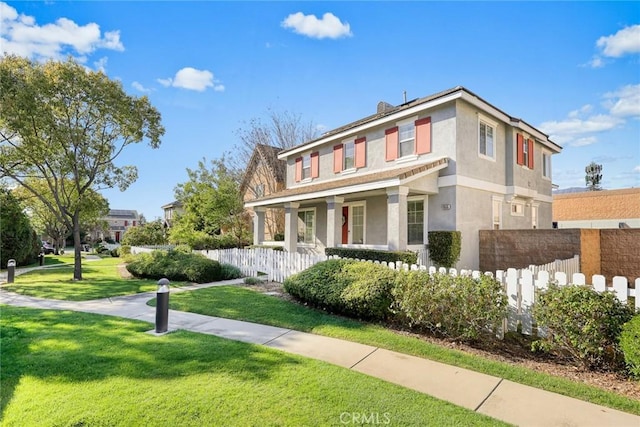 view of front of house featuring stucco siding, a front yard, and fence