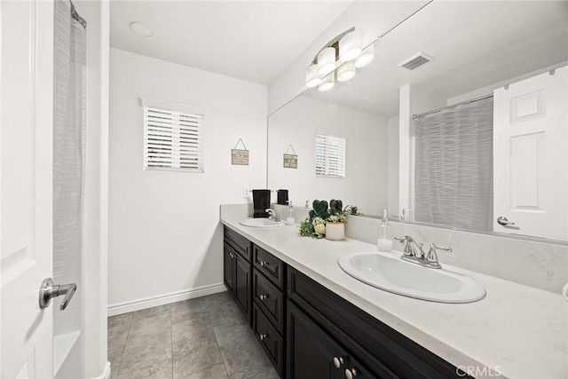 bathroom featuring double vanity, baseboards, visible vents, and a sink