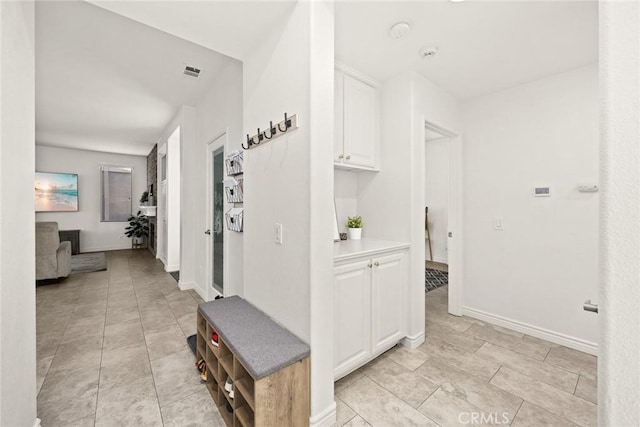 corridor featuring visible vents and baseboards