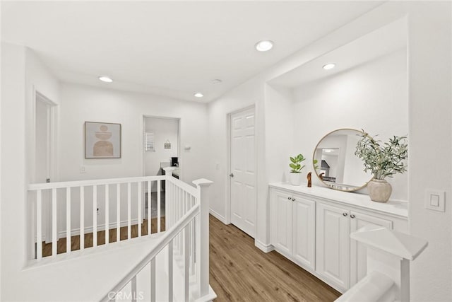 hall featuring recessed lighting, an upstairs landing, baseboards, and light wood finished floors