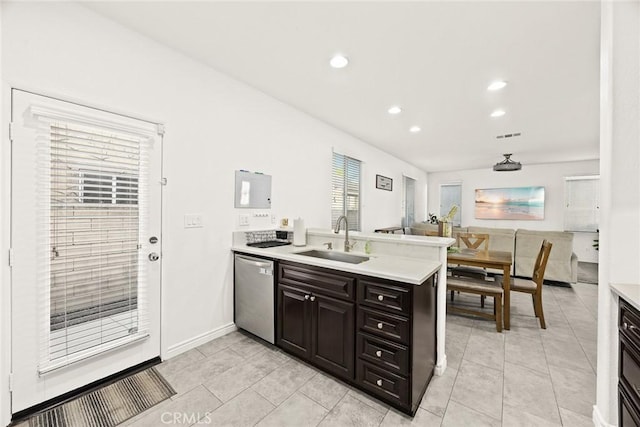 kitchen with dishwasher, a peninsula, light countertops, and a sink