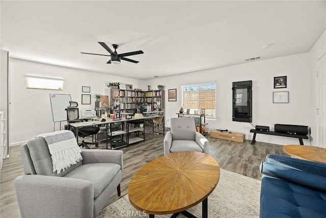 living area featuring visible vents, ceiling fan, and wood finished floors