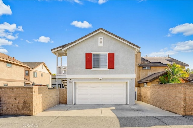 traditional-style house featuring stucco siding, an attached garage, driveway, and fence