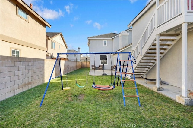 view of yard with a patio, stairs, a playground, and a fenced backyard