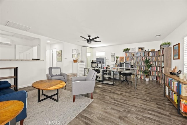 living room featuring ceiling fan, visible vents, wood finished floors, and a wall mounted AC