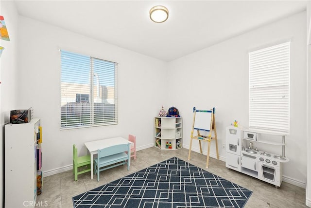 rec room featuring tile patterned flooring and baseboards