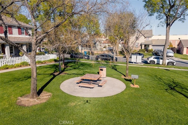 view of community featuring a yard, a residential view, and fence