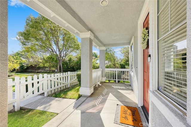 view of patio featuring a porch and fence