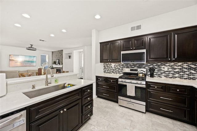 kitchen with appliances with stainless steel finishes, light countertops, and a sink