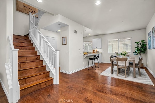 dining space featuring hardwood / wood-style floors, stairs, recessed lighting, and baseboards