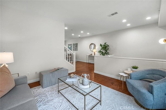 living area featuring recessed lighting, visible vents, wood finished floors, and stairs