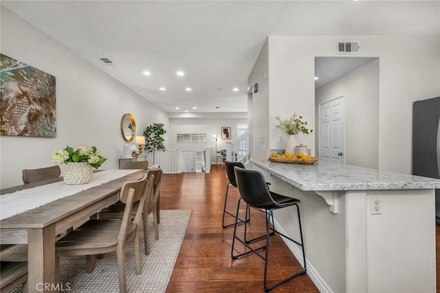 dining space with dark wood finished floors, visible vents, recessed lighting, and stairway