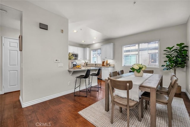 dining space with dark wood finished floors, recessed lighting, and baseboards