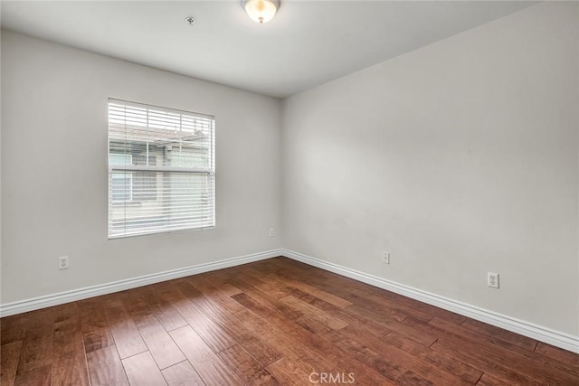 empty room featuring baseboards and hardwood / wood-style floors