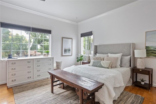 bedroom featuring crown molding and wood finished floors