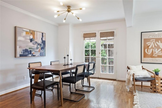 dining room featuring a wealth of natural light, french doors, crown molding, and wood finished floors