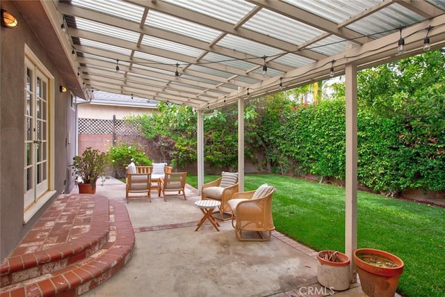 view of patio / terrace featuring french doors, a fenced backyard, outdoor dining space, and a pergola