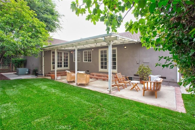 back of property with french doors, a patio, a lawn, and stucco siding