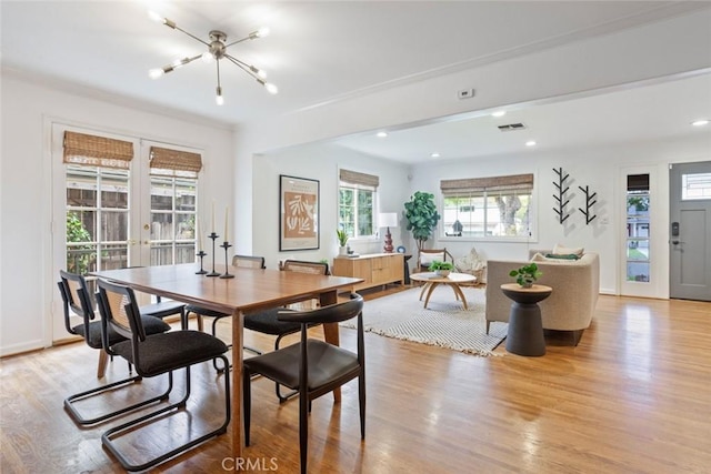 dining space with visible vents, light wood-style flooring, recessed lighting, french doors, and a chandelier