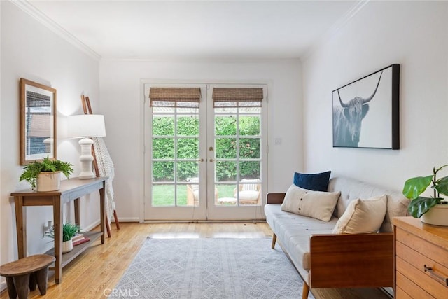 sitting room featuring a wealth of natural light, crown molding, and light wood-style floors