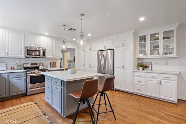 kitchen featuring visible vents, appliances with stainless steel finishes, gray cabinets, and white cabinetry