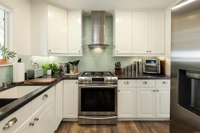 kitchen featuring stainless steel appliances, wall chimney exhaust hood, and white cabinets