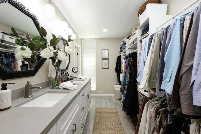 spacious closet with a sink and light wood-style flooring