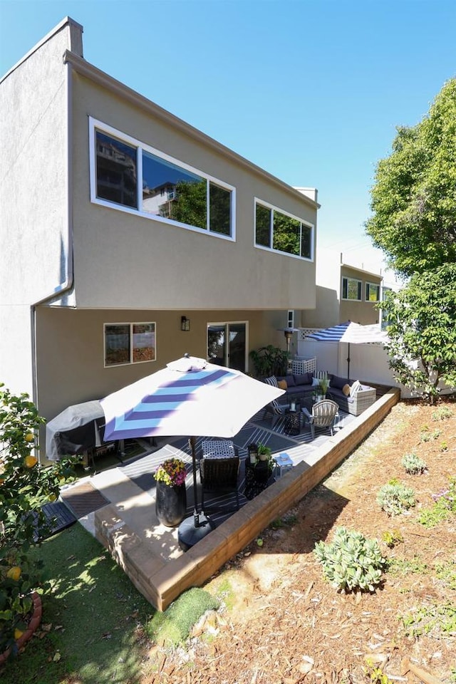 rear view of house with stucco siding and a patio