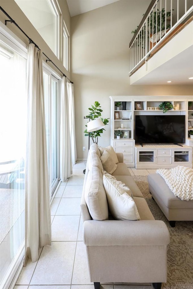 living area featuring a high ceiling and light tile patterned floors