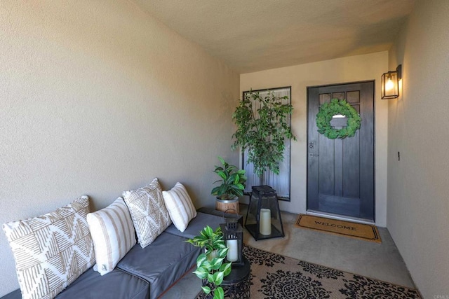 entrance to property with stucco siding and outdoor lounge area