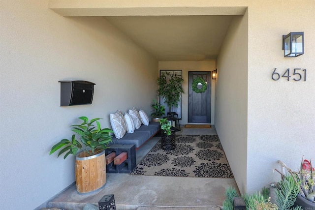 entrance to property featuring stucco siding and outdoor lounge area