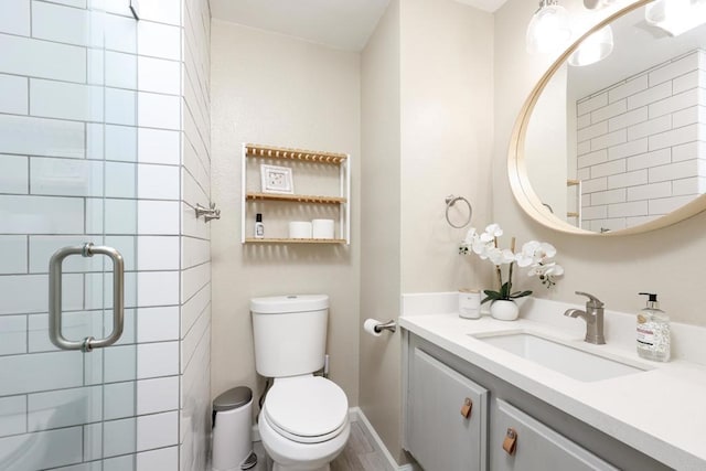 bathroom featuring baseboards, vanity, toilet, and a shower stall