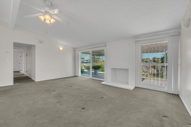 unfurnished living room with carpet flooring, a textured ceiling, baseboards, and a ceiling fan