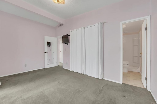 unfurnished bedroom featuring beam ceiling, carpet flooring, ensuite bathroom, and visible vents