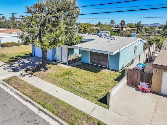 view of front facade with a garage, a front lawn, and fence