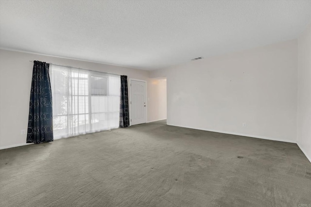 carpeted empty room featuring visible vents, baseboards, and a textured ceiling