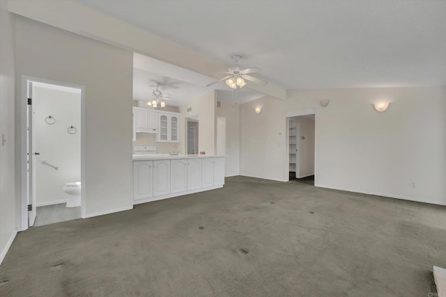 unfurnished living room with lofted ceiling with beams, baseboards, carpet, and a ceiling fan