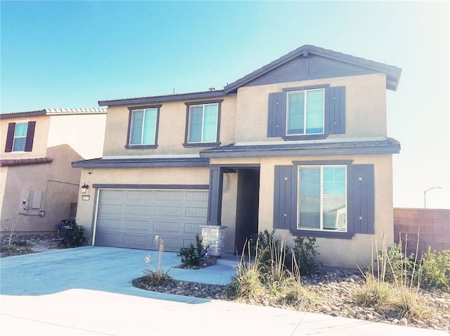 view of front of property featuring a garage, driveway, and stucco siding