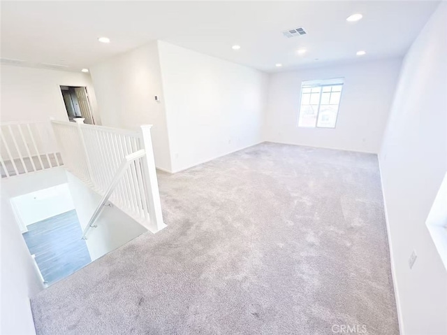 spare room with carpet flooring, recessed lighting, and visible vents