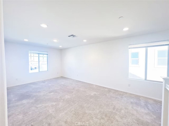 carpeted empty room with recessed lighting, visible vents, and baseboards