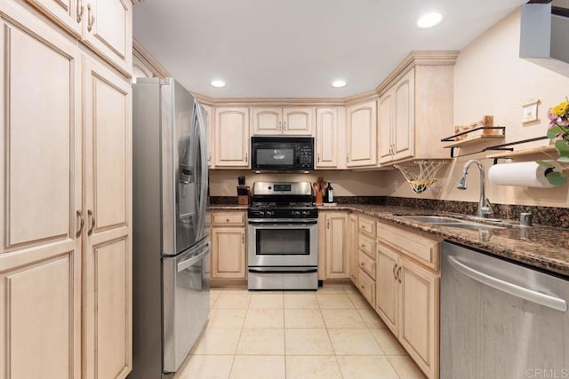 kitchen with a sink, recessed lighting, dark stone counters, appliances with stainless steel finishes, and light tile patterned flooring