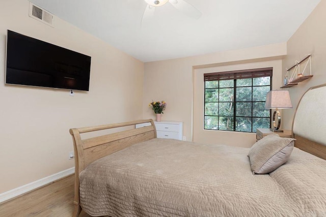 bedroom featuring ceiling fan, visible vents, baseboards, and wood finished floors