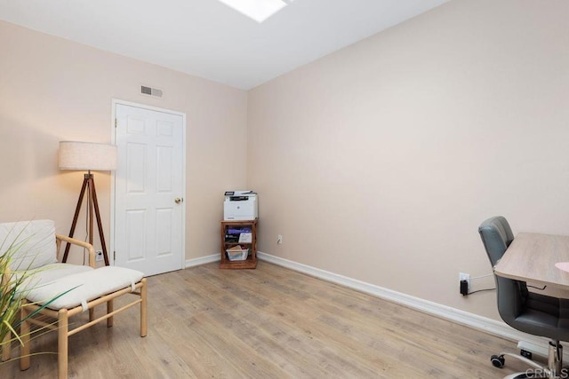 office space featuring light wood-style floors, visible vents, and baseboards