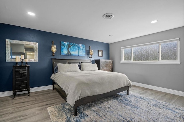 bedroom featuring recessed lighting, visible vents, baseboards, and wood finished floors