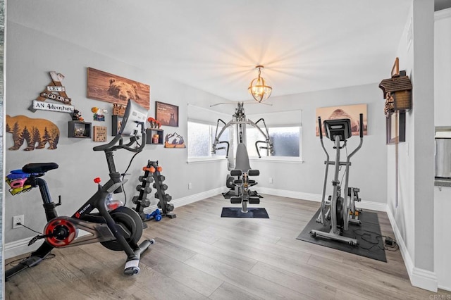 workout area featuring baseboards and wood finished floors