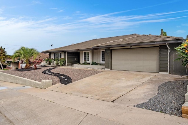 ranch-style house featuring concrete driveway, an attached garage, and a tile roof