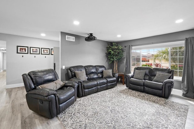 living room with recessed lighting, baseboards, visible vents, and light wood finished floors