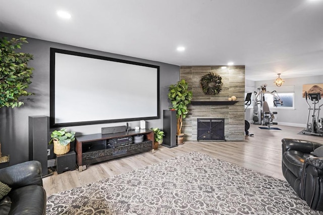 cinema room with recessed lighting, baseboards, wood finished floors, and a tiled fireplace