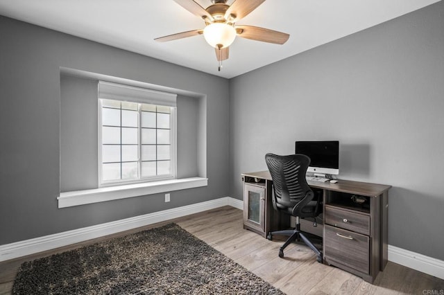 home office featuring light wood-type flooring, baseboards, and ceiling fan