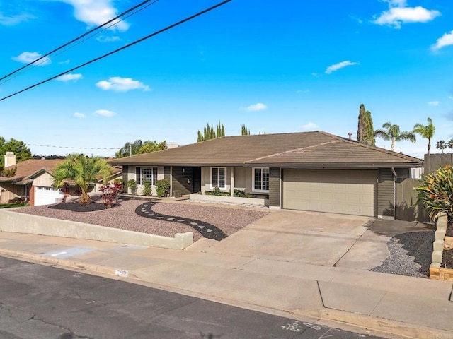 single story home with a tiled roof, an attached garage, and driveway